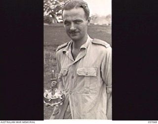 SOGERI AREA, NEW GUINEA, 1943-09-19. SX2934 MAJOR D. M. W. SANDS, OFFICER COMMANDING, 85TH AUSTRALIAN DENTAL UNIT, WITH AN ASH TRAY MADE BY HIM IN HIS SPARE TIME FROM SHELL AND CARTRIDGE CASES