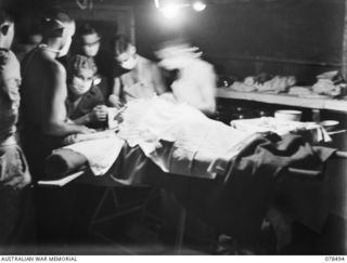 TAGESSI, BOUGAINVILLE ISLAND. 1945-01-16. NX402 MAJOR K.J. FRIEND, MEDICAL OFFICER, OPERATING ON A BATTLE CASUALTY FROM THE 47TH INFANTRY BATTALION AT THE MEDICAL DRESSING STATION OF THE 7TH FIELD ..