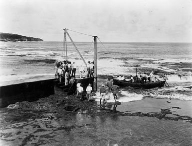 People on a boat, and bystanders, close to shore, Niue