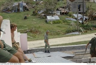 Replacing the lost roof on the Catholic Church at Pangi Village, Lifuka Island. Sapper Ted Cherry is to the left of the image and in the centre is Corporal Steve Ash This image relates to the ..