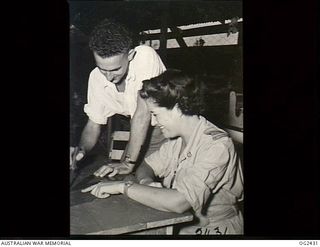 TOROKINA, BOUGAINVILLE ISLAND, SOLOMON ISLANDS. 1945-04-11. RED CROSS SENIOR SUPERINTENDENT SHEILA GRAHAM OF SYDNEY, NSW, INSTRUCTING 414586 CORPORAL H. T. MILLER OF BRISBANE, QLD, IN LEATHER WORK. ..