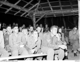 KALUMALAGI RIVER, NEW BRITAIN. 1945-02-24. AUSTRALIAN ARMY PERSONNEL TAKING A KEEN INTEREST IN THE ITEMS DURING A CONCERT STAGED AFTER THE OFFICIAL OPENING CEREMONY OF THE RECREATION HUT AT THE 5TH ..