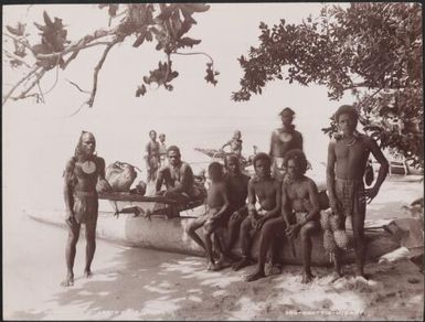 Men sitting on a canoe at a Vanikolo beach, Santa Cruz Islands, 1906 / J.W. Beattie