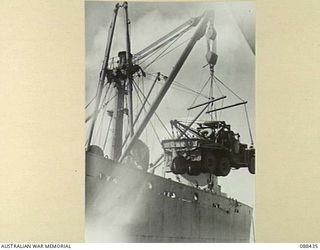 CAIRNS, QUEENSLAND. 1945-03-25. AN HEADQUARTERS 26 INFANTRY BRIGADE LAD BREAKDOWN VAN BEING LOADED ABOARD THE WILLIAM A. HENRY DURING EMBARKATION TO MILNE BAY