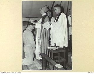 TOROKINA, BOUGAINVILLE, SOLOMON ISLANDS. 1945-03-14. VX114008 CAPTAIN D.C. DENNIS, 4TH BASE SUB-AREA (1), RECEIVES CONFIRMATION BY THE "LAYING ON OF HANDS" FROM THE ANGLICAN BISHOP OF NEW GUINEA, ..