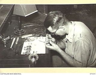 LAE, NEW GUINEA. 1944-03-24. NX39555 SERGEANT R. C. SMART REPAIRING ARMY WATCHES AT THE INSTRUMENT SHOP, AUSTRALIAN FORTRESS WORKSHOP