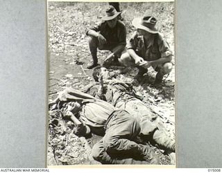 1943-06-15. NEW GUINEA. JAPANESE WOUNDED IN NEW GUINEA WAITING TO BE TAKEN TO AN ALLIED DRESSING STATION. (PHOTOGRAPHED BY G. SILK)