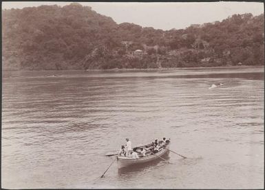 The Reverend C.C. Godden and crew in boat off shore of the mission station, Opa, New Hebrides, 1906 / J.W. Beattie