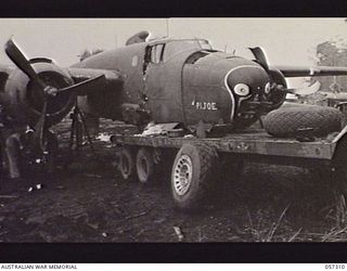 SOPUTA, NEW GUINEA. 1943-09-29. CRASHED MITCHELL BOMBER PI JOE AIRCRAFT IN WHICH BRIGADIER R. B. SUTHERLAND WAS KILLED, BEING LOADED ONTO A CRASH TENDER