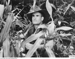1944-03-22. NEW GUINEA. PTE. A.B. GRAFFIN "PUDDIN" OF AN A.I.F. UNIT WHO ASSISTED IN MAKING THE DOCUMENTARY FILM "JUNGLE PATROL" PHOTOGRAPHED IN THE RAMU VALLEY AND FINISTERRE RANGE