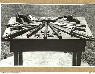 HOPOI DISTRICT, NEW GUINEA, 1943-10-30. COLLECTION OF JAPANESE WEAPONS TABLE HANDED IN TO NX155085 CAPTAIN R.G. ORMSBY OF THE AUSTRALIAN AND NEW GUINEA ADMINISTRATIVE UNIT ON HIS VISIT TO THE ..