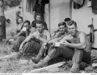 BUKAUA, NEW GUINEA. 1943-10-18. DINNER TIME FOR THE TROOPS OF THE 29/46TH AUSTRALIAN INFANTRY BATTALION AT THE LUTHERAN MISSION CHURCH. SHOWN: VX142226 PRIVATE (PTE) C. HAUTOT (1); VX84614 PTE G. ..