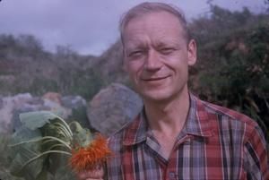 [Sherwin Carlquist holding an orange flowering plant in Wiliwilinui Ridge, United States]