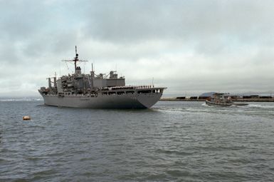 Crew members man the rails of the Mars-class combat store ship USS SAN JOSE (AFS 7) as it leaves Alameda, California, for its new home port in Guam