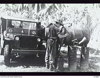 MADANG, NEW GUINEA. 1944-06-15. VX102888 DRIVER G. SHARP (LEFT) AND VX115970 DRIVER K. A. BROWN, REFUELLING FROM A PETROL POINT AT THE MOTOR TRANSPORT SECTION, HEADQUARTERS, 15TH INFANTRY BRIGADE. ..