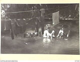 FINSCHHAFEN AREA, NEW GUINEA. 1944-03-13. NX123438 PRIVATE W. PATERSON (1), AND NX161750 PRIVATE A.G. BALDERSTON (2), MEMBERS OF THE 101ST BRIGADE SUPPORT COMPANY, WASH CLOTHES IN A CREEK NEAR THE ..