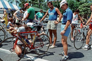 An official inspects an entrant's bicycle prior to the start of the bicycle race, part of the 1987 Ironman Competition