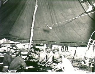 THE SOLOMON ISLANDS, 1945-10. FIVE JAPANESE SERVICE PERSONNEL BEING INTERROGATED BY AUSTRALIAN SOLDIERS. (RNZAF OFFICIAL PHOTOGRAPH.)