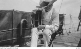 NEW GUINEA. C. 1914. GUNNER YEO, OF THE AUSTRALIAN NAVY AND MILITARY EXPEDITIONARY FORCE (AN&MEF), EXAMINING THE KEY OF A MINE WHICH WAS UNEARTHED ON THE BITA PAKA ROAD. IT WAS OF ENGLISH MAKE, ..