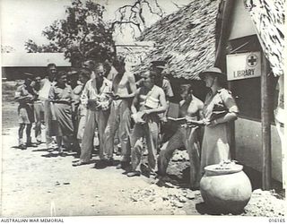 NEW GUINEA. 1943-11-19. RED CROSS WORKERS AND CONVALESCENTS AT A RED CROSS CENTRE AT AN AUSTRALIAN FIELD HOSPITAL LINE UP AT THE LIBRARY