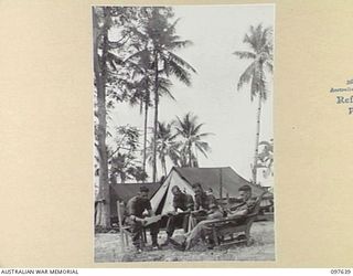 NAURU ISLAND. 1945-10-02. FOLLOWING THE SURRENDER OF THE JAPANESE, TROOPS OF 31/51 INFANTRY BATTALION OCCUPIED THE ISLAND. SHOWN, MEMBERS OF HEADQUARTERS COMPANY RESTING AGAINST A BACKGROUND OF THE ..