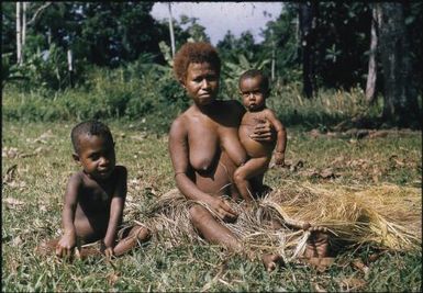 A woman making the skirt (held by her big toe) : Environs of Mapamoiwa, D'Entrecasteaux Islands, Papua New Guinea, 1956 / Terence and Margaret Spencer