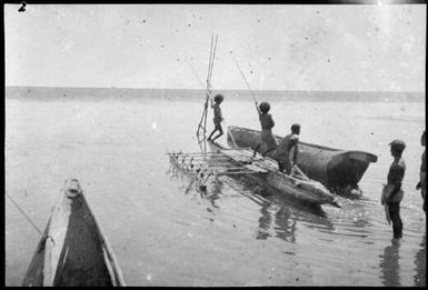 Three men in an outrigger canoe levering a lakatoi hull, Motuan, Port Moresby, Papua, ca. 1923, 2 / Sarah Chinnery