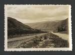 View of railway tracks and road, mountain range in background, New Zealand?