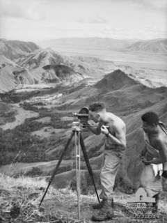 FARIA RIVER AREA, NEW GUINEA. 1943-11-07. VX102393 SERGEANT D. KINNA, MILITARY HISTORY SECTION TAKING A PANORAMIC VIEW OF THE RAMU VALLEY FROM SHAGGY RIDGE