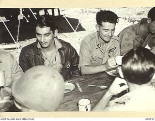 JACKSON'S DROME, PORT MORESBY, PAPUA, 1944-02. AUSTRALIAN AND AMERICAN AIRMEN DISCUSSING EXPERIENCES OVER THEIR MID DAY MEAL AT JACKSON'S DROME. THESE MEMBERS OF THE ROYAL AUSTRALIAN AIR FORCE ARE ..