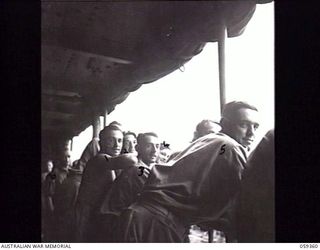NEW GUINEA. 1943-10-28. TROOPS OF THE 2/1ST AUSTRALIAN TANK ATTACK REGIMENT RETURNING TO AUSTRALIA ON LEAVE, LINE THE RAILS ABOARD THE MV "CANBERRA". SHOWN: NX12973 GUNNER (GNR) R. P. TATHAM (1); ..