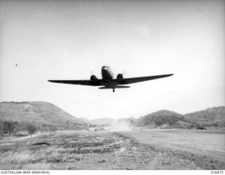 PAPUA, NEW GUINEA. 1942-08. DOUGLAS C47 DAKOTA TRANSPORT AIRCRAFT TAKING OFF FROM KILA KILA AIRFIELD, NEAR PORT MORESBY ON A SUPPLY DROPPING MISSION TO THE KOKODA AREA