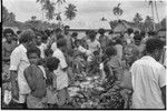 Mortuary ceremony: people with piles of yams, taro, and betel nut to be distributed to mourners