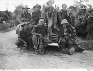 RABAUL, NEW BRITAIN, 1945-09-13. MR JOHN THOMPSON, AUSTRALIAN BROADCASTING COMMISSION WAR CORRESPONDENT (5), AND SERGEANT N. KELLY, ARMY PUBLIC RELATIONS JOURNALIST (6), WITH MEMBERS OF 5 MILITARY ..