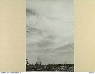 1943-01-12. PAPUA. BUNA. JAPANESE DIVE BOMBERS ATTACK ALLIED POSITIONS AT BUNA. IN THIS PICTURE A DIVE BOMBER STRAIGHTENS OUT AFTER DROPPING IT'S LOAD. SMOKE FROM A BOMB BURST CAN BE SEEN IN THE ..