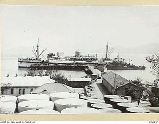 PORT MORESBY, PAPUA. 1942-08. 2/1ST HOSPITAL SHIP MANUNDA ALONGSIDE THE WHARF AT PORT MORESBY BEING LOADED WITH WOUNDED FOR EVACUATION TO AUSTRALIA. NOTE THE MOTOR AMBULANCES DRAWN UP ON THE WHARF