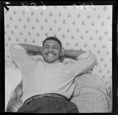 Fijian heavyweight boxing champion Mosese Varisikete relaxing on his hotel bed, probably Wellington Region