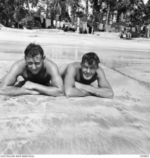 WIRUI BEACH, WEWAK, NEW GUINEA. 1945-09-04. PRIVATE F. HANSER (1) AND PRIVATE L.P. MILLS (2), MEMBERS OF 2/11 INFANTRY BATTALION RESTING ON THE BEACH