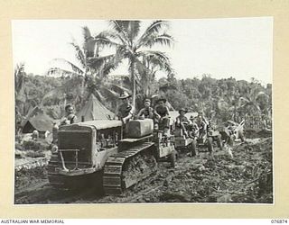 JACQUINOT BAY, NEW BRITAIN. 1944-11-11. A TRACTOR TRAIN TAKING A LOAD OF SUPPLIES TO THE CAMP AREA OF THE 14/32ND INFANTRY BATTALION. IDENTIFIED PERSONNEL ARE: VX86259 PRIVATE J.P. LAVELLE (4), ..