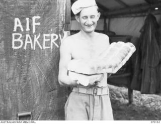 DUMPU, NEW GUINEA. 1944-02-05. VX144774 PRIVATE K.J. SHARROCK (1) DISPLAYING ROLLS AT THE 15TH INFANTRY BRIGADE BAKERY