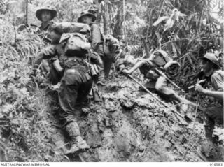 1944-04-21. NEW GUINEA: AFTER A 5000 FT. CLIMB IN THE FINNISTERRES THE TROOPS FOUND THE MUD JUST AS DEEP AS ON THE LOWER SLOPES. TROOPS ON THE FINAL STAGE OF THE CLIMB