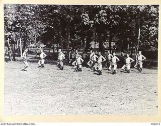 YALU, NEW GUINEA. 1945-08-03. WARRANT OFFICER 1 B.H. TURNER, REGIMENTAL SERGEANT MAJOR, NEW GUINEA TRAINING SCHOOL CONDUCTING THE PHYSICAL TRAINING CLASS