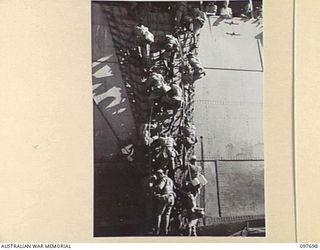 TOROKINA, BOUGAINVILLE. 1945-09-21. JAPANESE TROOPS FROM NAURU ISLAND CLAMBERING DOWN THE SIDE OF THE SS RIVER BURDEKIN INTO BARGES WHICH WILL TAKE THEM ASHORE AT TOROKINA FROM WHENCE THEY WILL ..