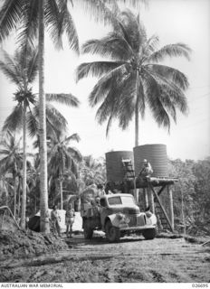 MILNE BAY, PAPUA. 1942-09. THIS WATER POINT, TO SUPPLY AUSTRALIAN TROOPS IN THE GILI GILI AREA, IS SET IN A TROPICAL SETTING IN A COCONUT PLANTATION
