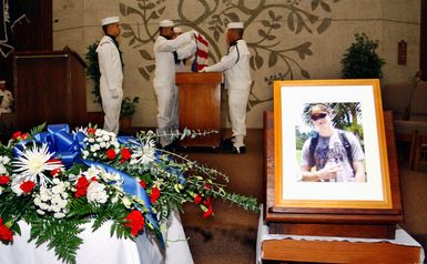 U.S. Navy (USN) L.Y. Spear Class Submarine Tender USS FRANK CABLE (AS 40) Sailors fold an American flag in memory of USN Machinery Repairman Fireman (MRFN) Jack Valentine during a memorial service held in the chapel at Naval Base Guam, on Dec. 10, 2006. MRFN Valentine died on Dec. 8 at Brooke Army Medical Center in San Antonio, TX, from injuries sustained during a Dec. 1 boiler explosion aboard the Guam based submarine tender. The flag will be hand delivered to Valentine's family by USN CAPT. Leo Goff, the ship's commanding officer. (U.S. Navy photo by Mass Communication Second Class Stefanie Broughton) (Released)