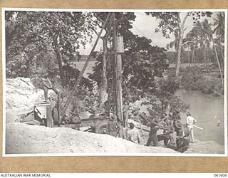 BUMI RIVER, FINSCHHAFEN AREA, NEW GUINEA. 1943-11-24. A PILE BEING HAULED INTO POSITION FOR DRIVING DURING THE CONSTRUCTION OF A BRIDGE ACROSS THE BUMI RIVER BY ENGINEERS OF THE 2/3RD AUSTRALIAN ..