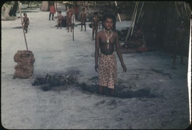 A village woman standing in a hole for burying coconuts, children in background : Tasman Islands, Papua New Guinea, 1960 / Terence and Margaret Spencer