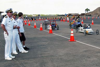 US Navy (USN) Commander (CO) Naval Station (NS) Pearl Harbor, Hawaii (HI), Captain (CAPT) Tyler Skardon (left) and CO Navy Region (NR) Hawaii, Admiral (ADM) Michael Vitali, enjoy watching US military personnel compete in a 10-lap race at the 11th annual Hawaiian Electric Electron Marathon on Ford Island, Pearl Harbor
