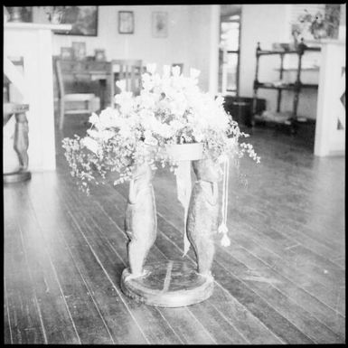 Mixed flowers draped over a Trobriand Island stool, Rabaul, New Guinea, ca. 1936 / Sarah Chinnery