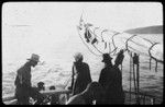 Men on a ship, looking out to sea